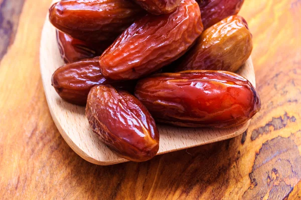 Dried dates on spoon wooden background — Stock Photo, Image