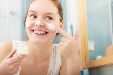 Woman applying moisturizing skin cream. Skincare. clipart