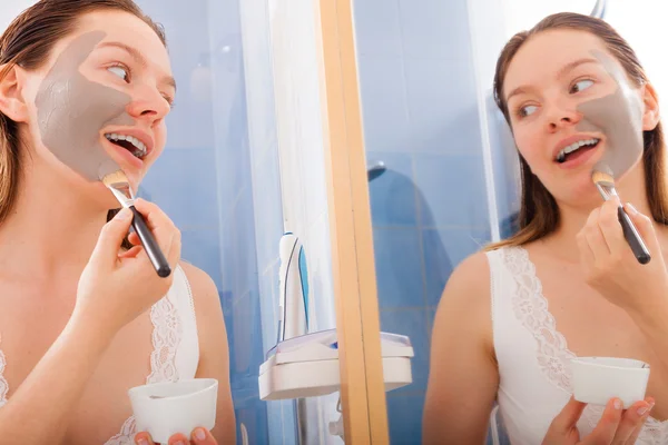 Woman applying mud facial mask — Stock Photo, Image