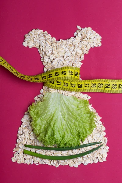 Dress shape made from oatmeal with measuring tape — Stock Photo, Image