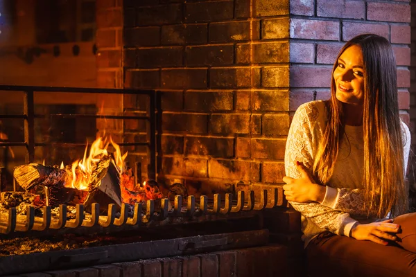 Happy woman relaxing at fireplace — Stock Photo, Image