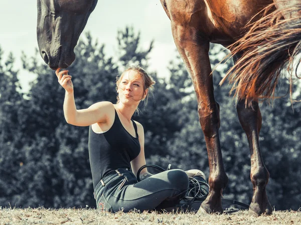 Ung kvinna tjej utfodring häst. — Stockfoto