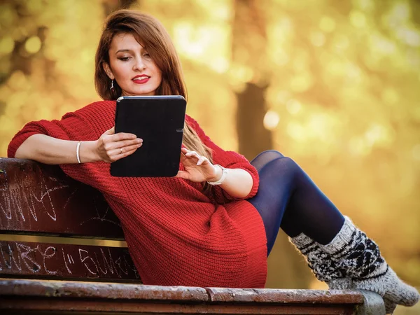 Mujer en el parque de otoño usando tableta — Foto de Stock