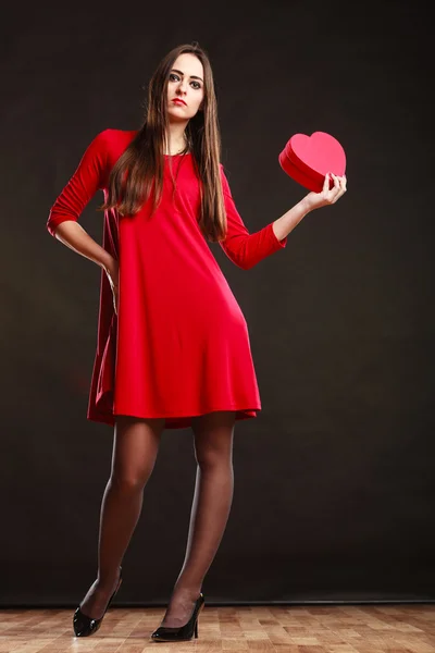 Mulher em vermelho dressholding coração amor símbolo — Fotografia de Stock