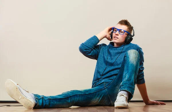 Hombre con auriculares sentado en el suelo — Foto de Stock