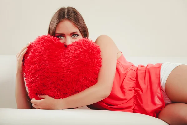 Frau umarmt Kissen in Herzform. Valentinstag. — Stockfoto