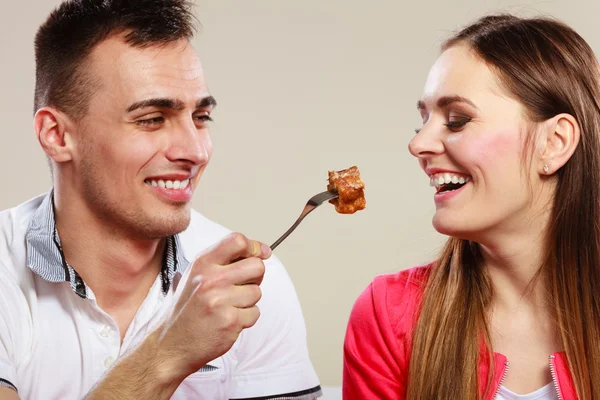 Человек кормит счастливую женщину — стоковое фото