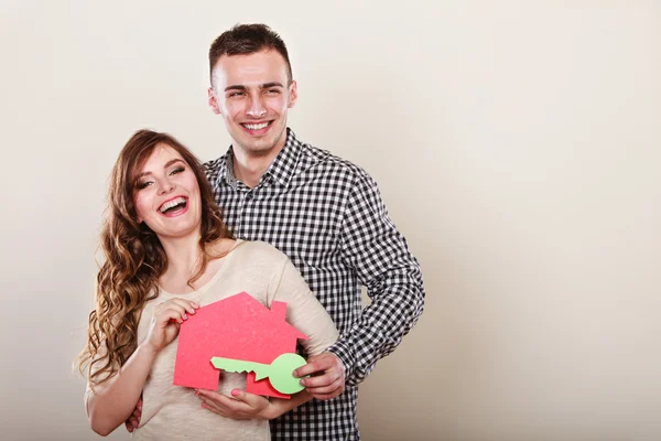 Young couple holding paper house — Stockfoto