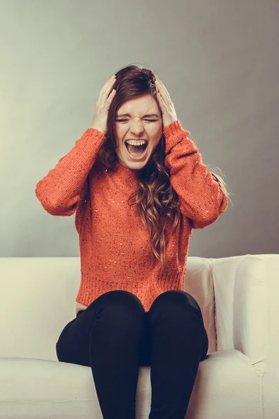 Gestresste junge Frau sitzt auf Sofa — Stockfoto