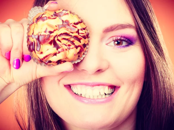 Divertida mujer sostiene pastel en la mano cubriendo su ojo —  Fotos de Stock