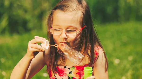 Little girl blowing soap bubbles — Stock Photo, Image