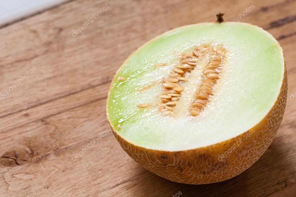Melon with pips on table Stock Photo by ©Voyagerix 82972818