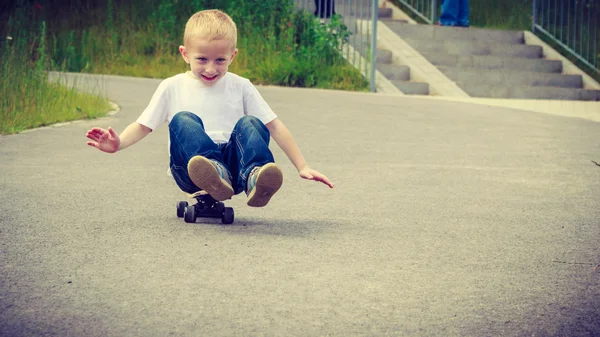 Bambino seduto sullo skateboard — Foto Stock