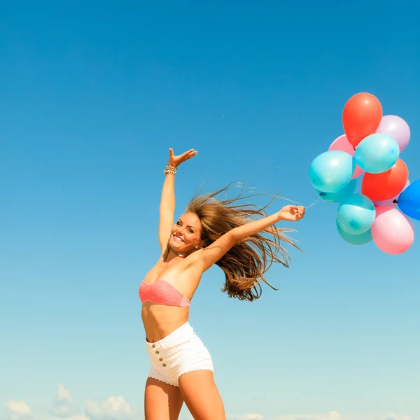 Chica saltando con globos de colores en el fondo del cielo —  Fotos de Stock