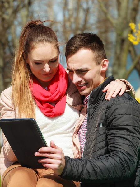 Couple with  tablet sitting on bench — Stock Photo, Image