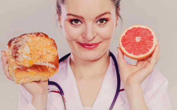 Ernährungsberaterin mit Brötchen und Grapefruit — Stockfoto