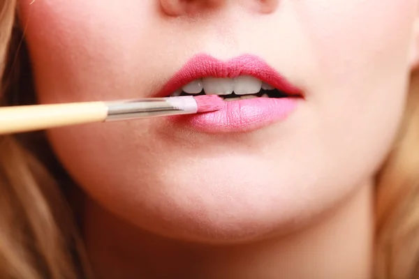 Vrouw die roze lippenstift aanbrengt — Stockfoto