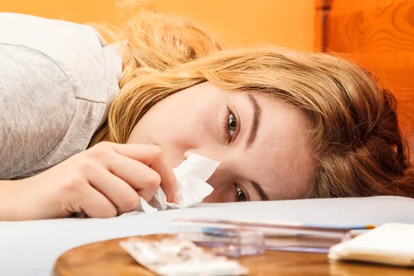 Woman laying in bed sneezing — Stock Photo, Image