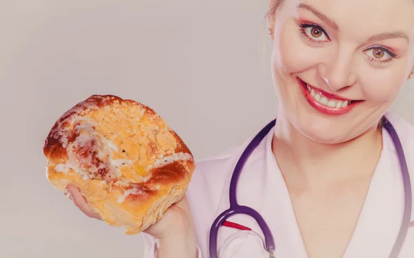 Dietitian with sweet roll bun. Unhealthy junk food — Stock Photo, Image