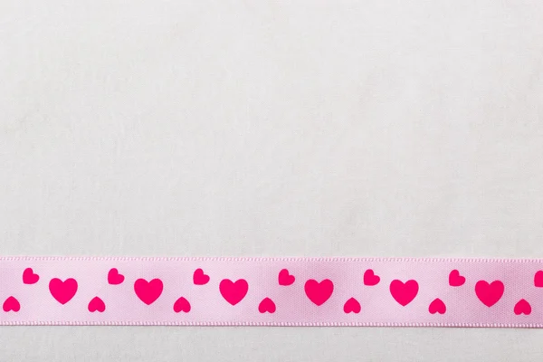 Розовая лента сердца на фоне ткани — стоковое фото