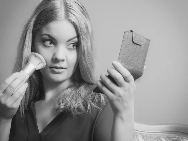 Atractiva mujer que aplica maquillaje con cepillo. — Foto de Stock