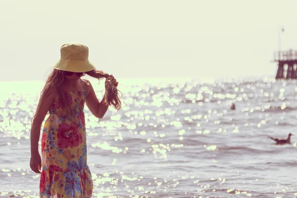 Liten flicka kid promenader på stranden till sjöss. Kul. — Stockfoto