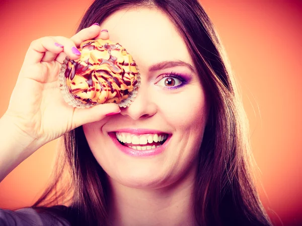 Engraçado mulher segura bolo na mão cobrindo seu olho — Fotografia de Stock