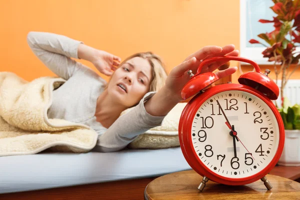 Woman waking up turning off alarm clock — Stock Photo, Image