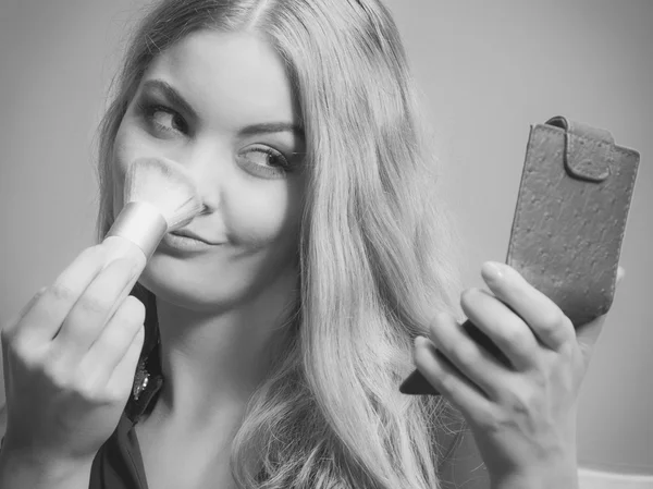 Mujer aplicando maquillaje con pincel . — Foto de Stock