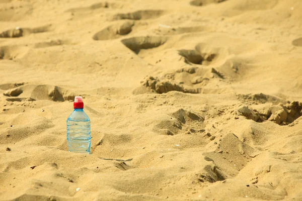 Plastic bottle  on a sandy summer beach — Stock Photo, Image