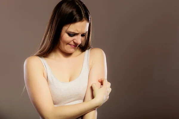 Woman scratching her arm — Stock Photo, Image