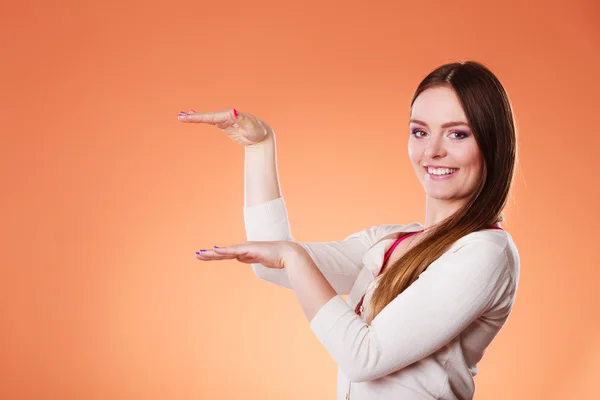 Mujer sonriente sosteniendo la palma abierta con la mano vacía — Foto de Stock