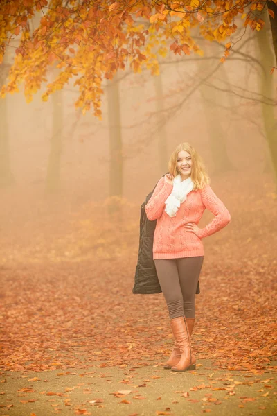 Lächelnde blonde Frau mit Jacke im Park. — Stockfoto