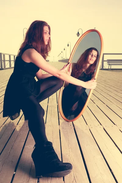 Woman looking reflection in the mirror — Stock Photo, Image