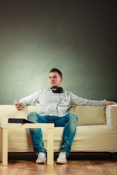 Man relaxing on couch with headphones — Stock Photo, Image