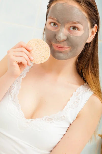 Kvinna med facial clay mask på ansiktet — Stockfoto