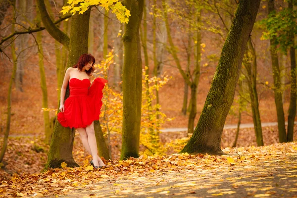 Moda mulher vestido vermelho relaxante andando no parque — Fotografia de Stock