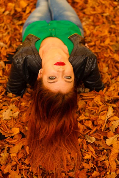 Retrato de mujer joven en hojas de otoño. — Foto de Stock