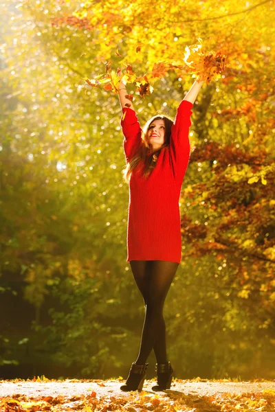 Femme se détendre dans le parc d'automne jetant des feuilles dans l'air — Photo