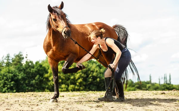 Ung kvinna tjej ta hand om hästen. — Stockfoto