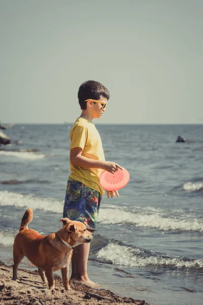 Petit garçon enfant avec chien s'amusant sur la plage — Photo