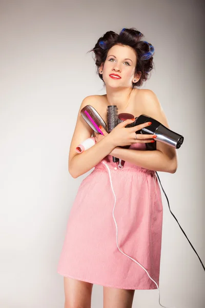 Funny girl styling hair holds many accessories — Stock Photo, Image