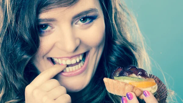 Smiling cute woman holds fruit cake in hand — Stock Photo, Image