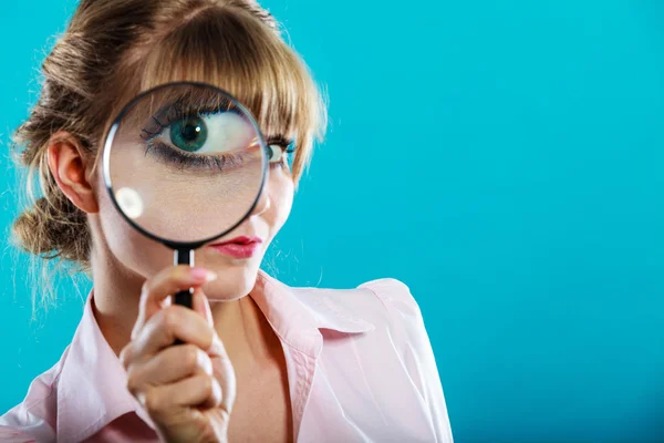 Woman hand holding magnifying glass on eye — Stock Photo, Image