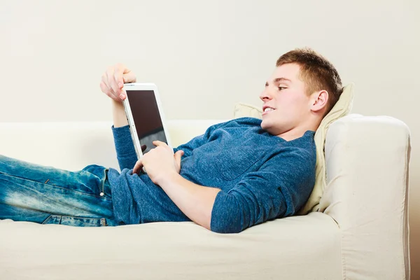 Dijital tablet kanepe döşeme ile genç adam — Stok fotoğraf