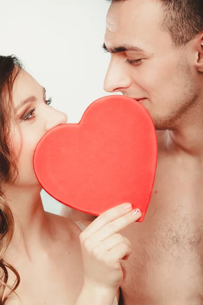 愛情のあるカップルが赤いハートの後ろにキスします。愛. — ストック写真