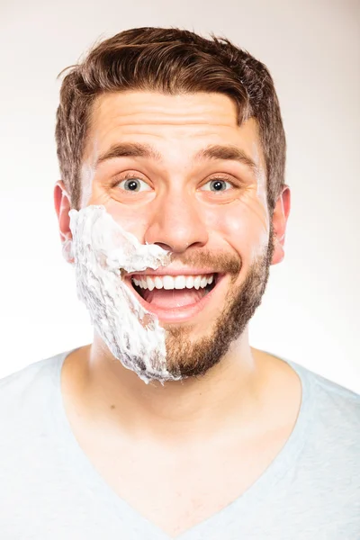 Glücklicher Mann mit Rasierschaum auf der Gesichtshälfte. — Stockfoto