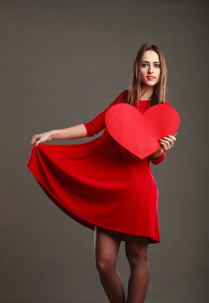 Kırmızı elbiseli kadın kalp işareti tutar — Stok fotoğraf