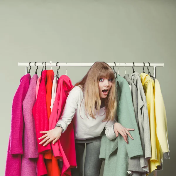 Mulher sorrateira entre as roupas — Fotografia de Stock