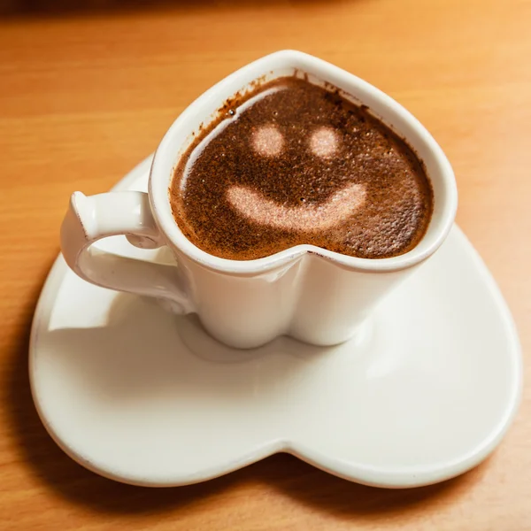 Coffee in heart shaped cup with smile face sign — Stock Photo, Image